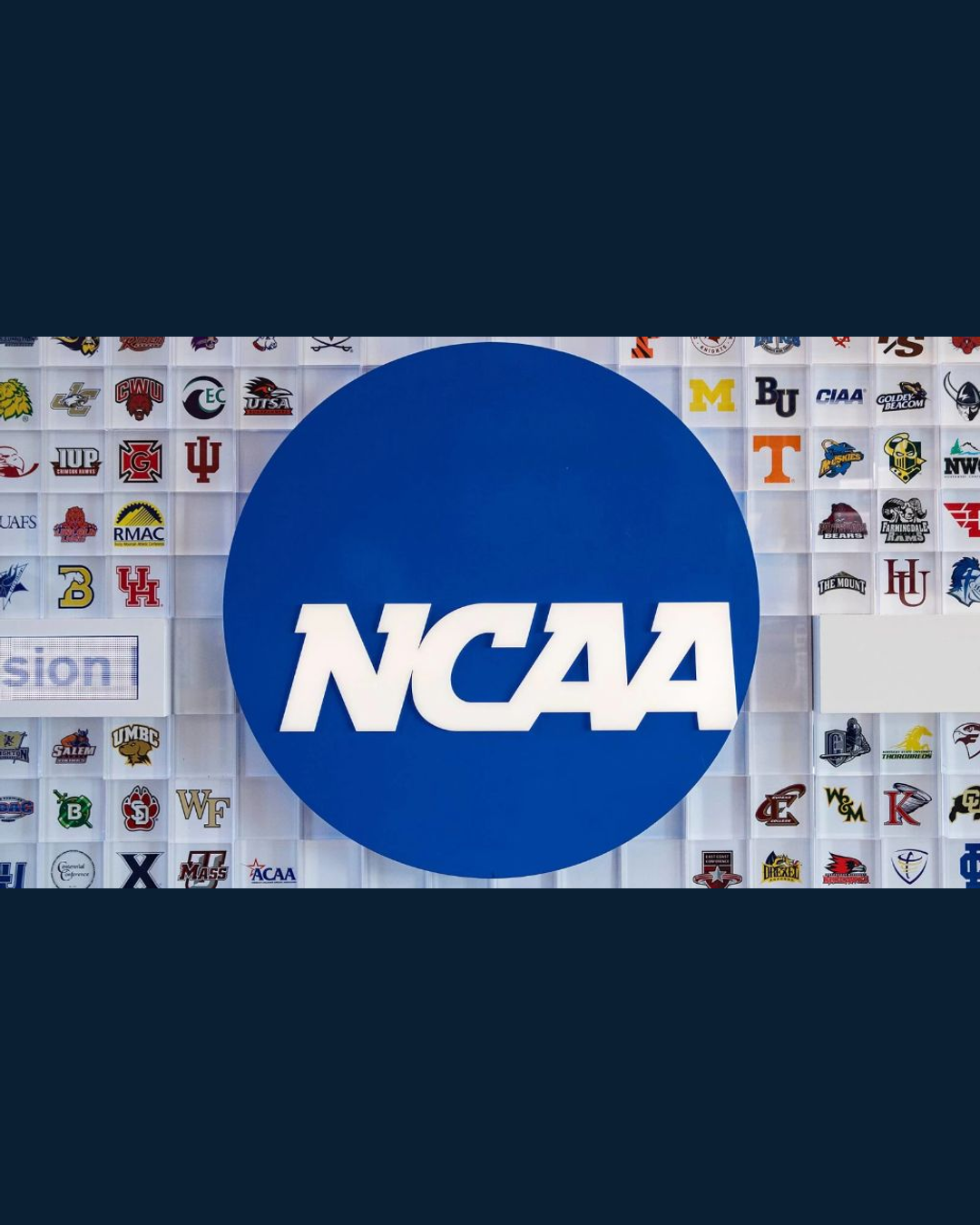 The NCAA logo mounted on a wall of member-school shields at NCAA headquarters.
